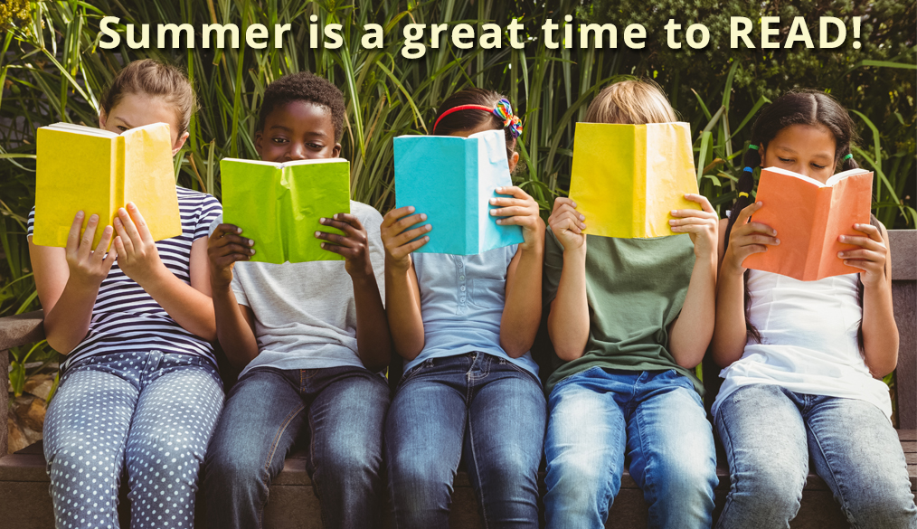 children sitting in a row holding up open books, reading