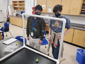 student and teacher looking at science project