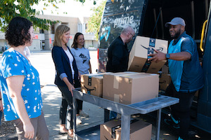 volunteers unloading boxes from an Amazon van